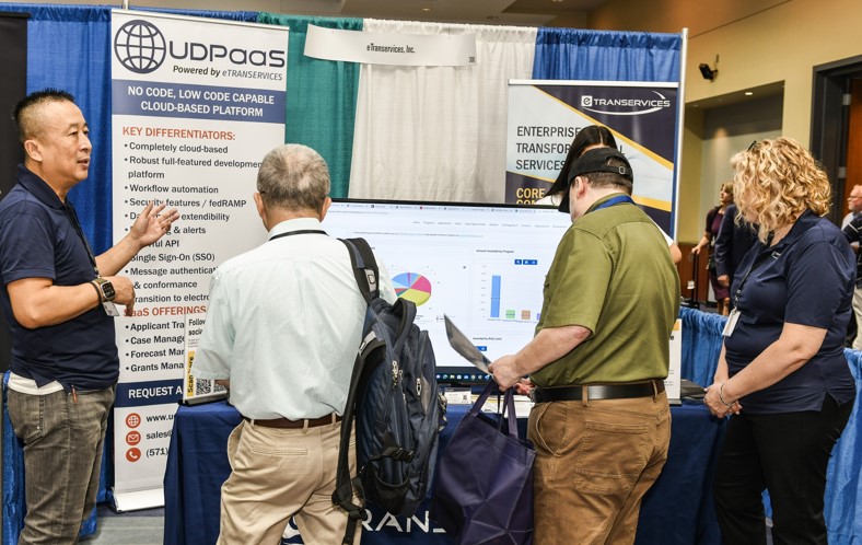 Men and women visiting a booth at an expo event