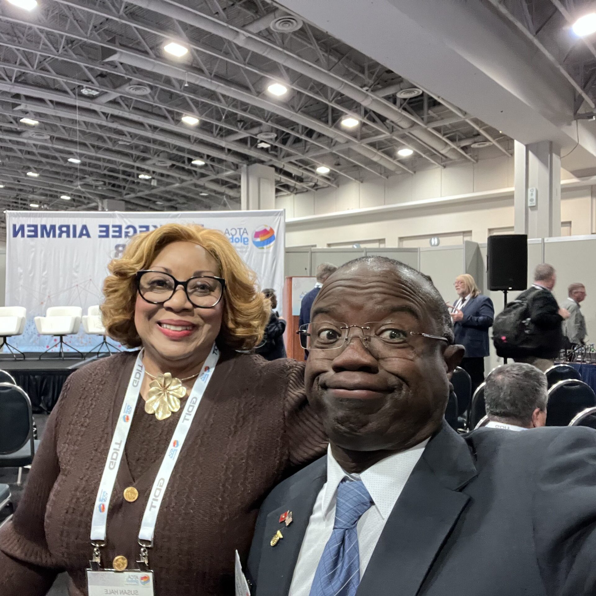 A man making a goofy face with a smiling woman during an event