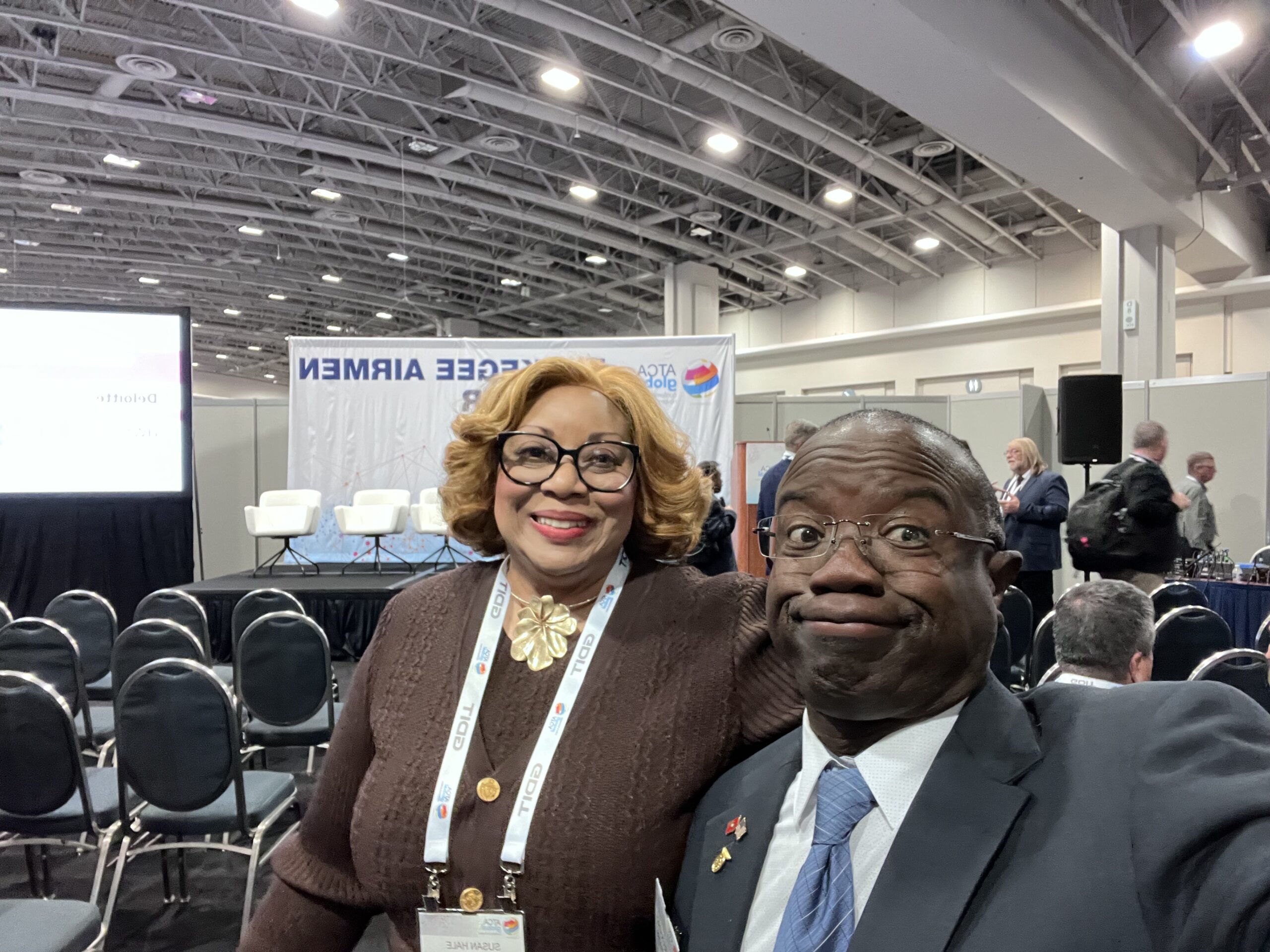 A man making a goofy face with a smiling woman during an event